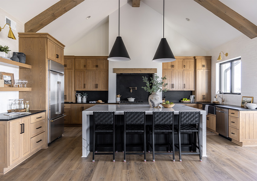wood flooring in modern kitchen with wood cabinets and black accents